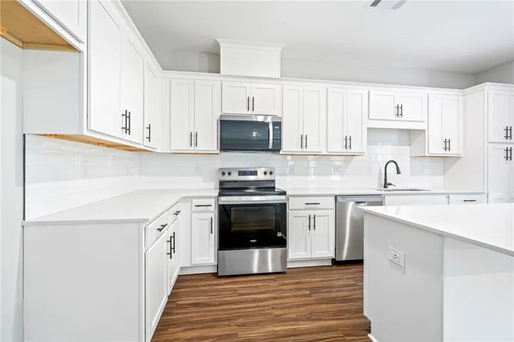 Crisp white cabinetry paired with modern stainless steel appliances highlights this contemporary culinary space.