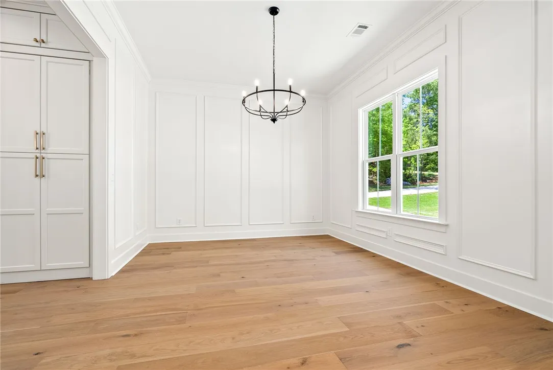 The dining room, finished with floor-to-ceiling millwork, sits at the front of the home with direct access to the kitchen and easy proximity to the foyer.