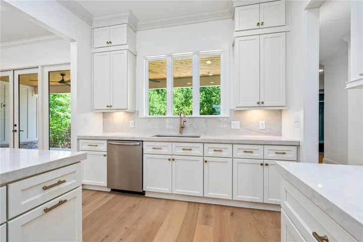 Two ovens, ceiling-height cabinetry, abundant natural light, a sink overlooking the backyard, and a spacious hidden pantry—everything a well-designed kitchen should offer.