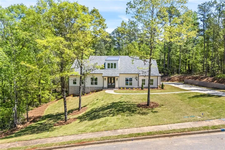 This newly constructed home features a charming exterior and a spacious lot with a private driveway.