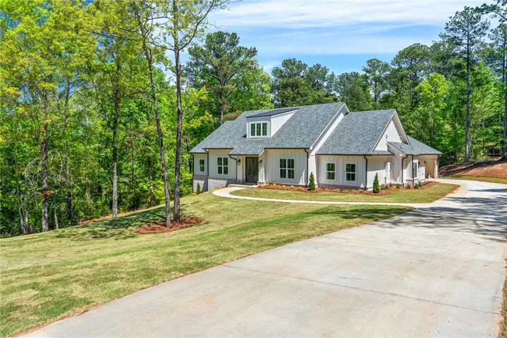 A long, wide driveway offers ample space for play and parking, while the approach to the front door is welcoming for guests.