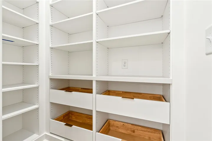 The pantry is concealed behind cabinetry-panel doors, creating a sleek and highly functional layout.