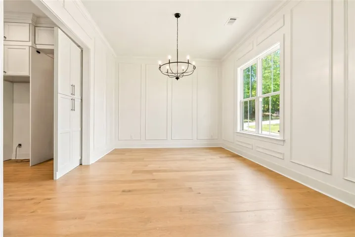 Located at the entry and adjacent to the kitchen, the dining room features oversized windows and floor-to-ceiling millwork.