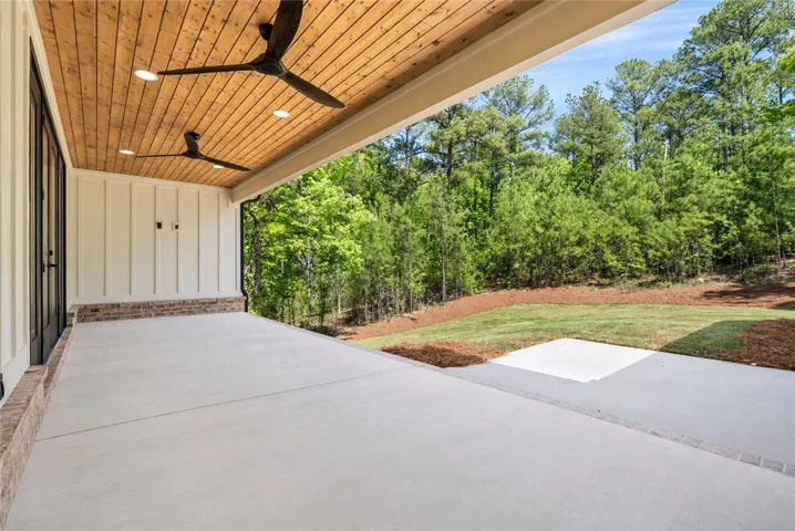 A tongue-and-groove ceiling with dual fans for warm-weather comfort and direct access to the great room ensure that the porch is an inviting space for outdoor living with serene views of the surrounding landscape.