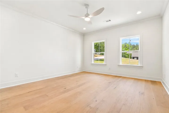 Wood flooring extends into the primary bedroom.