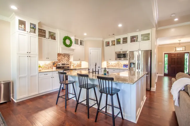 Spacious kitchen features ample counter space with an L-shaped island plus cabinets that go to the ceiling.