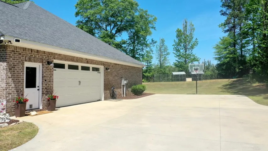 This residence features a basketball court, garage, and charming brick exterior.
