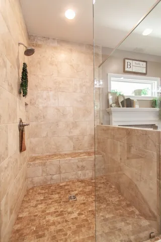 This spacious shower features elegant tile work and a convenient built-in bench for ultimate comfort.