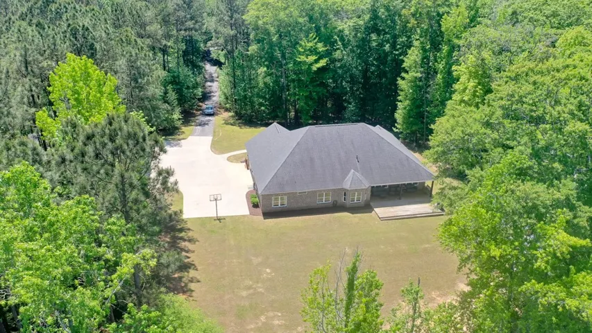 This tranquil estate offers a private driveway, a spacious lawn, and a large covered patio for serene outdoor living.