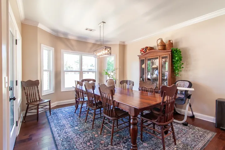 Elegant dining space perfect for memorable gatherings, featuring ample natural light and rich hardwood floors.