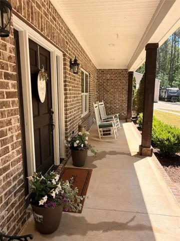 This inviting porch, perfect for relaxing, welcomes you with classic brickwork and natural light.