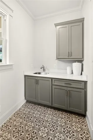 This functional laundry area features ample storage and a charming patterned tile floor.