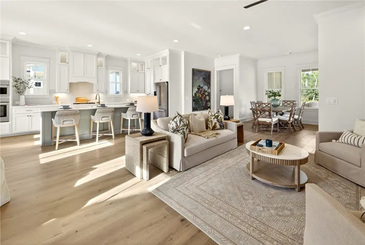 This bright open-concept living space features light wood flooring and abundant natural light.