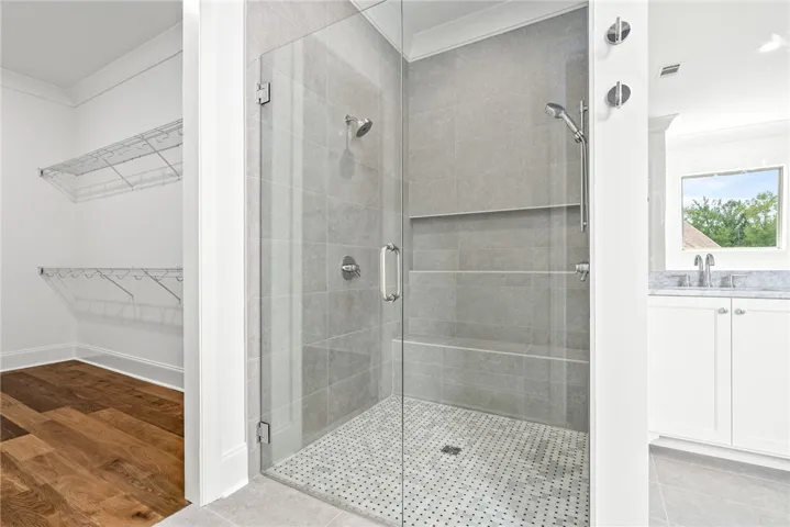 The frameless, fully tiled shower features a built-in bench and a spacious tile niche for toiletries.
