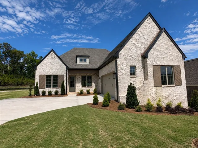 This charming residence features an inviting facade with classic brick and wood accents.