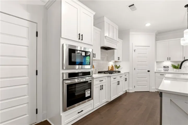Bright and airy kitchen featuring pristine white cabinetry and modern appliances.