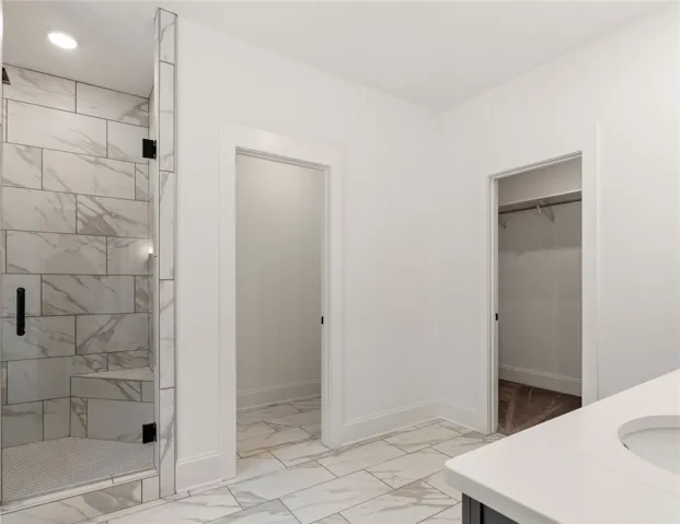 This modern bathroom features a spacious walk-in shower and elegant tile flooring.