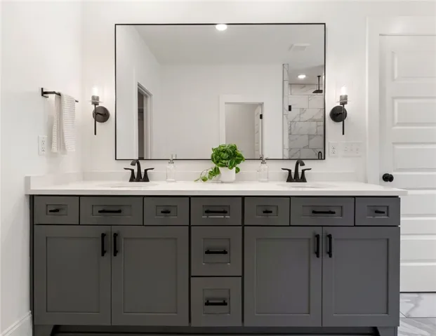 This primary bathroom offers a dual vanity with ample storage and modern fixtures.