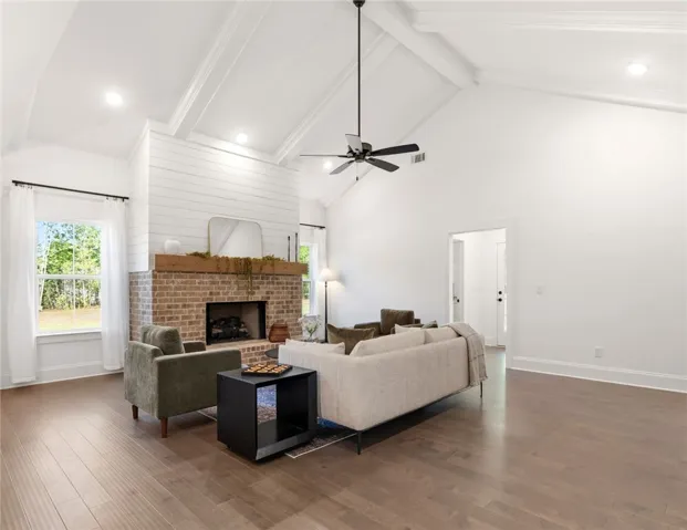 This bright living space features high ceilings and a welcoming fireplace, perfect for gatherings.