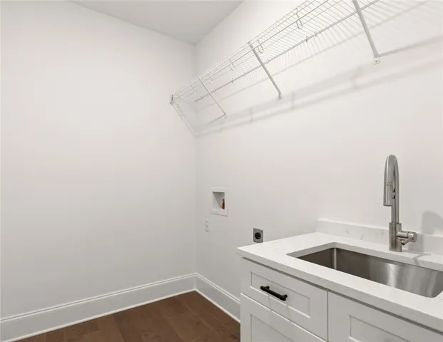 Functional laundry space with a utility sink and wire shelving for effortless organization.