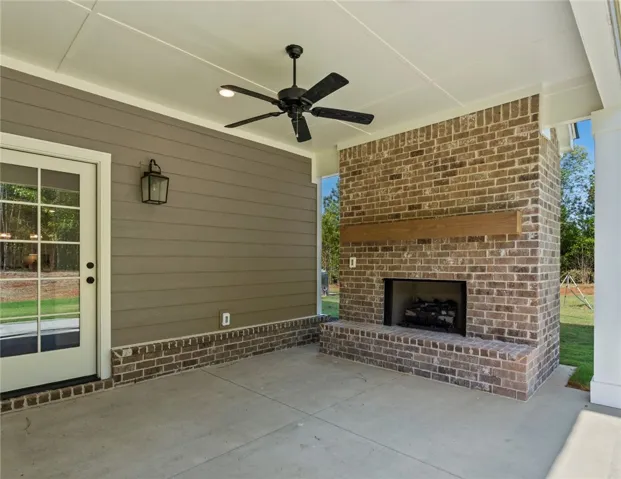 This inviting covered patio features a beautiful brick fireplace, perfect for outdoor relaxation and entertaining.