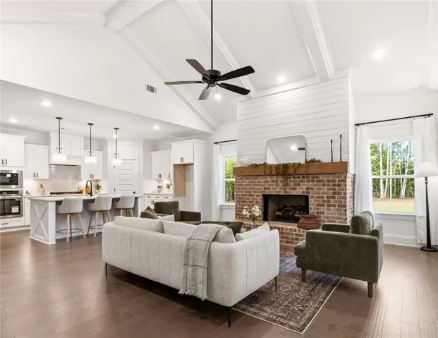 This bright, open concept living area features a warm fireplace and spacious kitchen.