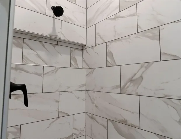 This shower features large format tile walls, creating a clean and modern bathing space.