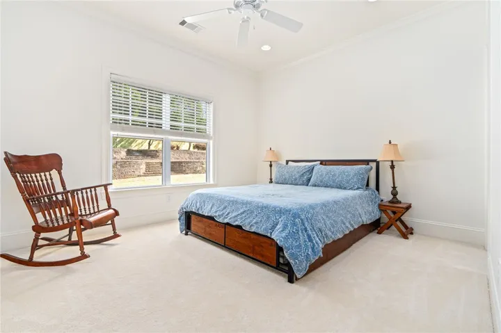 This spacious first floor bedroom offers ample natural light and comfortable carpeting, perfect for peaceful rest.