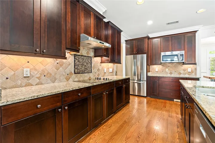 This spacious kitchen offers ample storage, expansive countertops, and modern stainless steel appliances.
