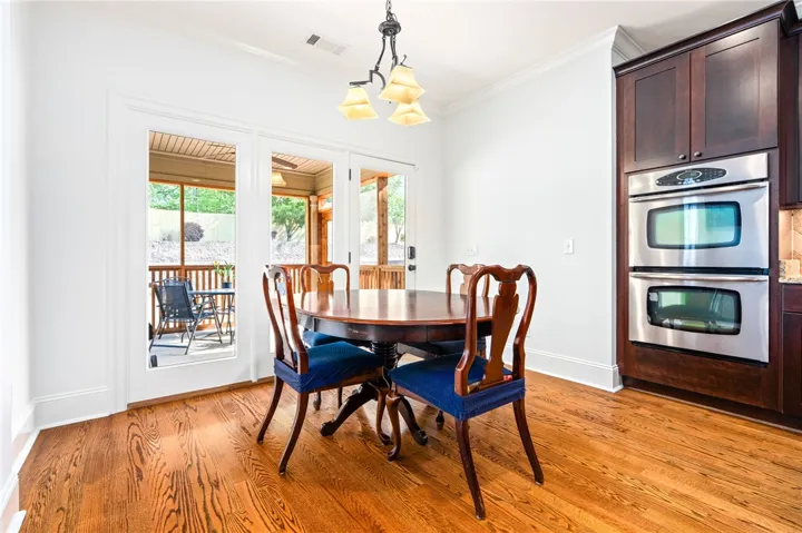 This bright kitchen features outdoor access, rich wood floors, and modern stainless steel appliances.
