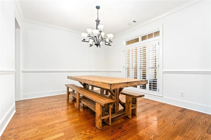 This bright dining room features rich hardwood flooring and elegant window shutters. Freshly painted throughout.