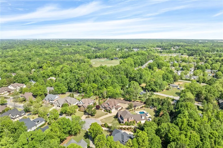 This elevated view captures a serene residential landscape nestled amidst expansive greenery & a short golf cart ride to Moores Mill Club.
