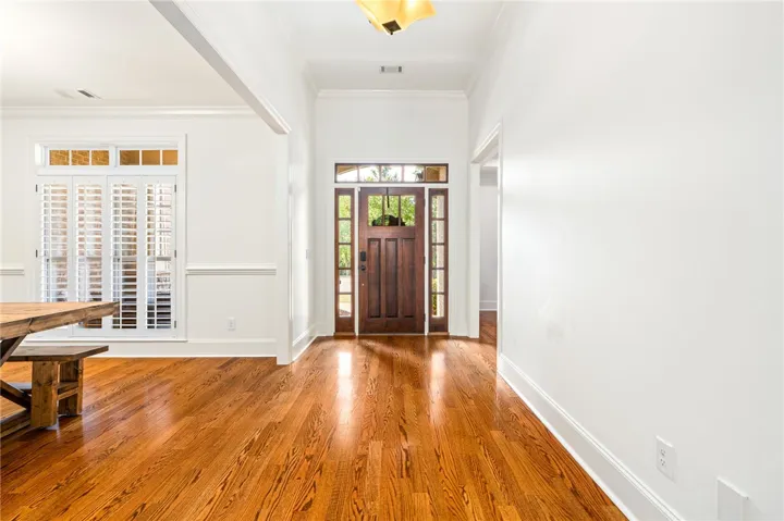 Step into a luminous entryway featuring lustrous hardwood floors and abundant natural light.