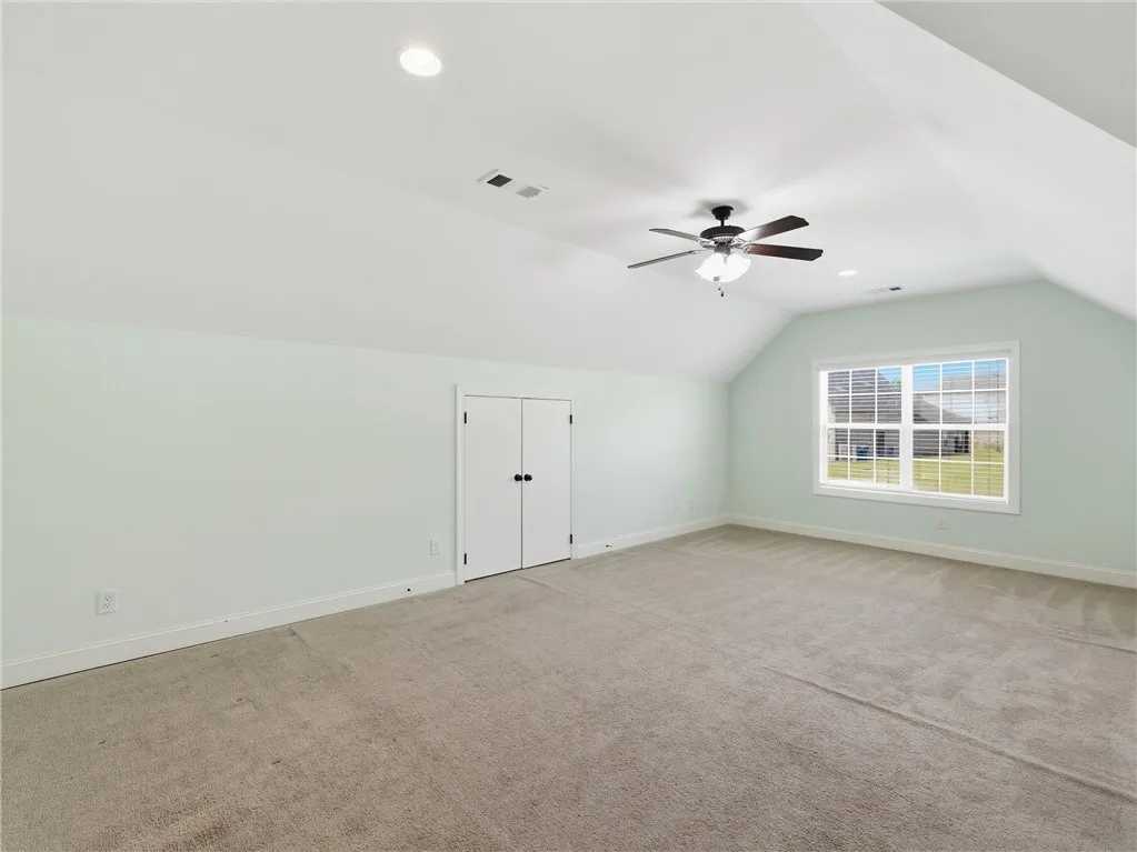 This spacious room features vaulted ceilings, recessed lighting, and soft carpeting, perfect for a peaceful retreat.