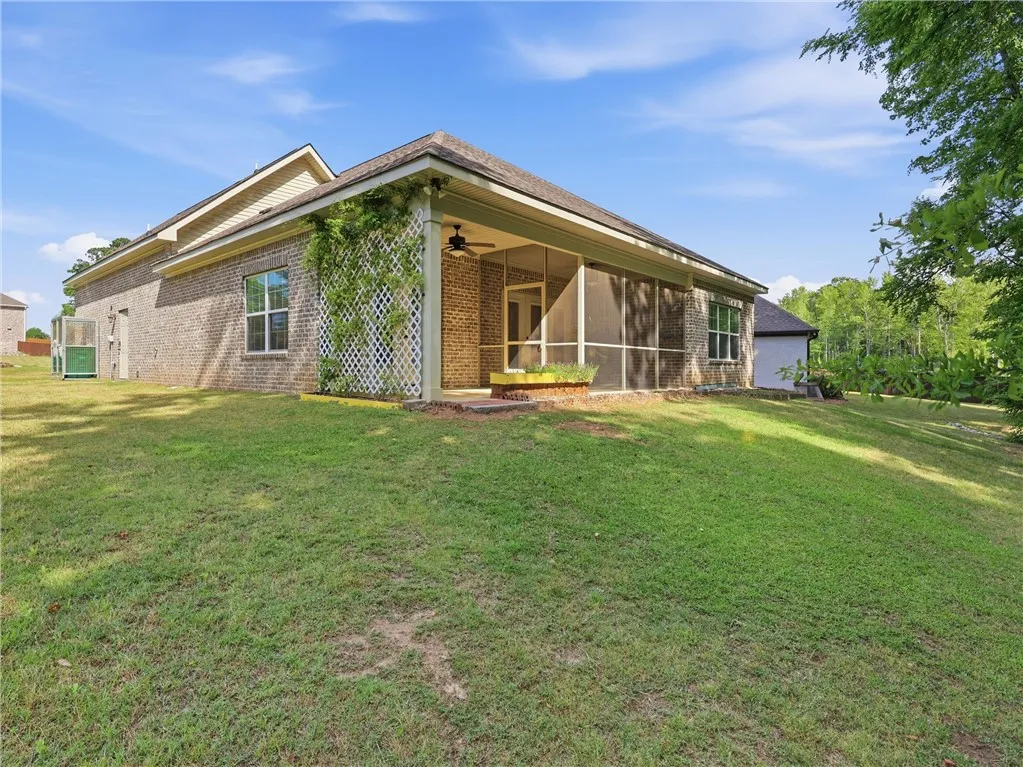 This residence features a large yard, screened porch, and brick exterior for comfortable living.
