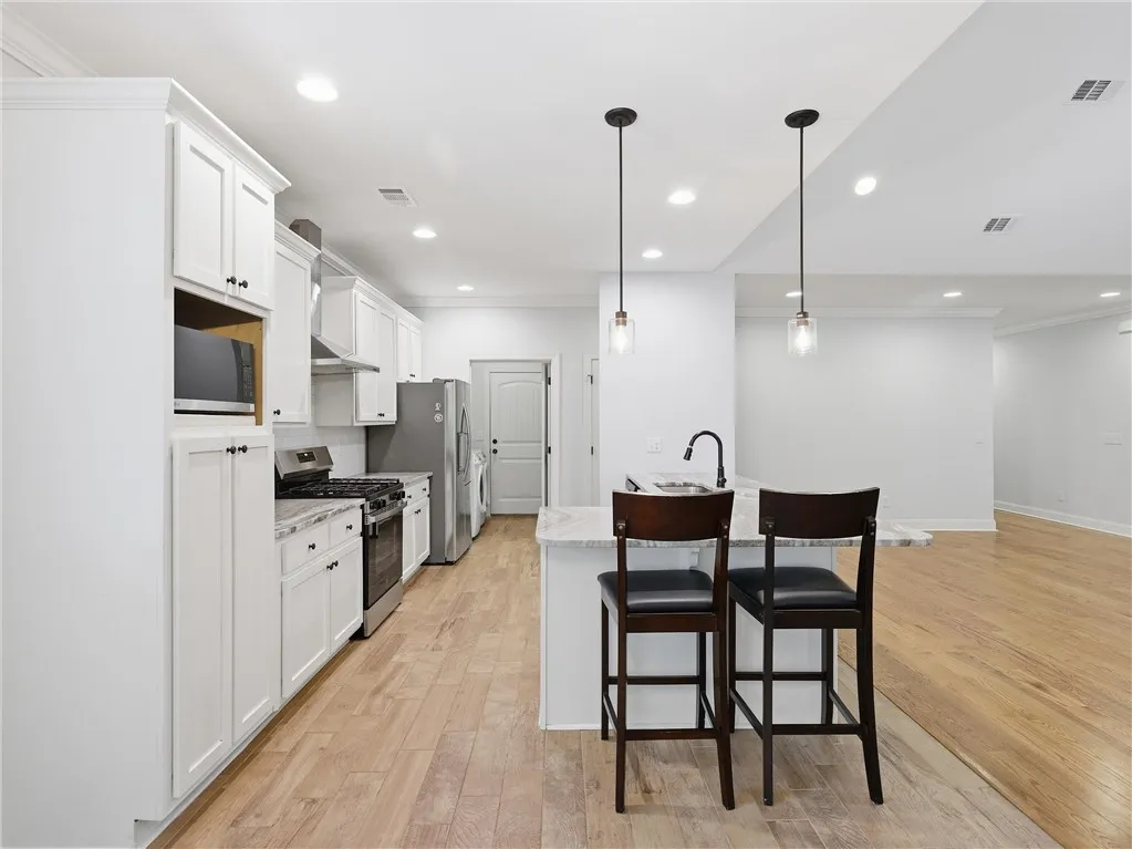 This bright kitchen features modern appliances and an inviting island, perfect for casual dining and entertaining.