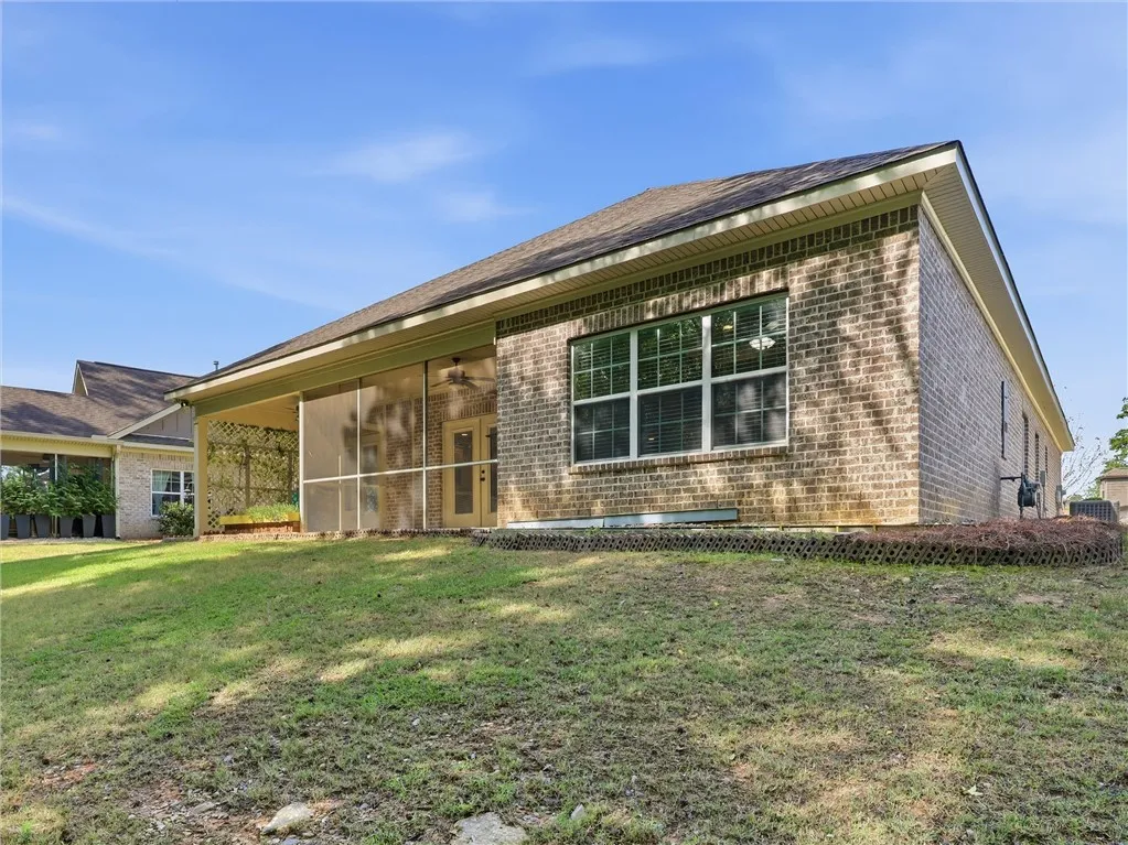 This residence features a screened porch and a brick exterior, offering comfortable outdoor living.
