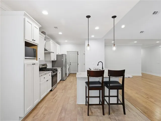 This bright kitchen features modern appliances and an inviting island, perfect for casual dining and entertaining.