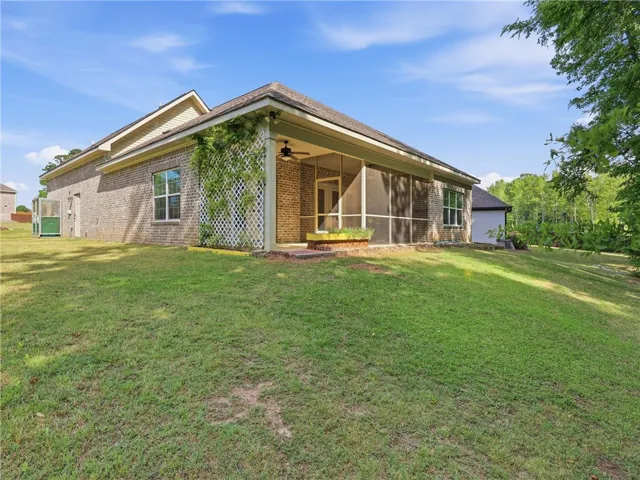 This residence features a large yard, screened porch, and brick exterior for comfortable living.