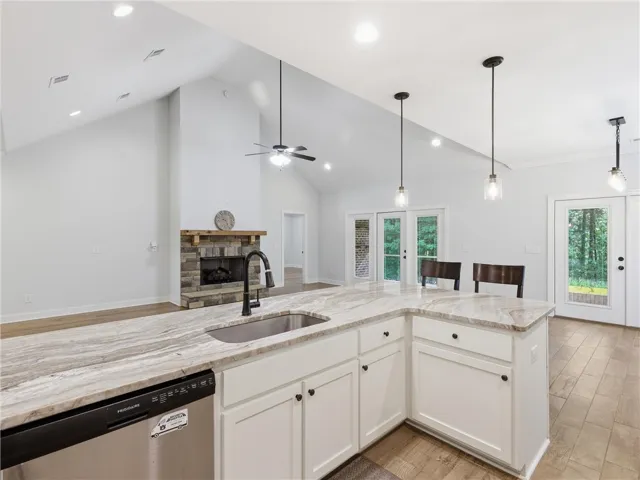 This spacious kitchen and living area features a grand fireplace and direct outdoor access.