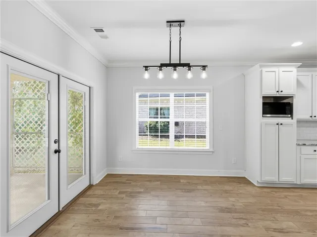 This bright dining area features elegant crown molding and durable tile flooring, perfect for everyday living.