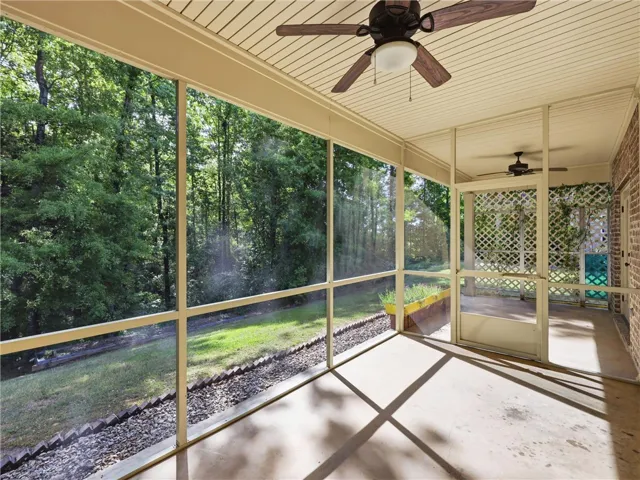 This serene screened porch offers a tranquil retreat with abundant natural light and outdoor views.