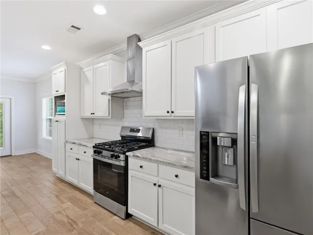 This modern kitchen features crisp cabinetry, gleaming countertops, and durable flooring.