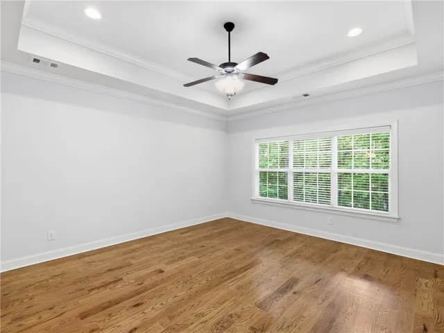 This airy room features rich hardwood flooring and a stylish tray ceiling.