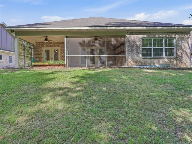 This residence features a large backyard with a covered patio and screened-in porch.