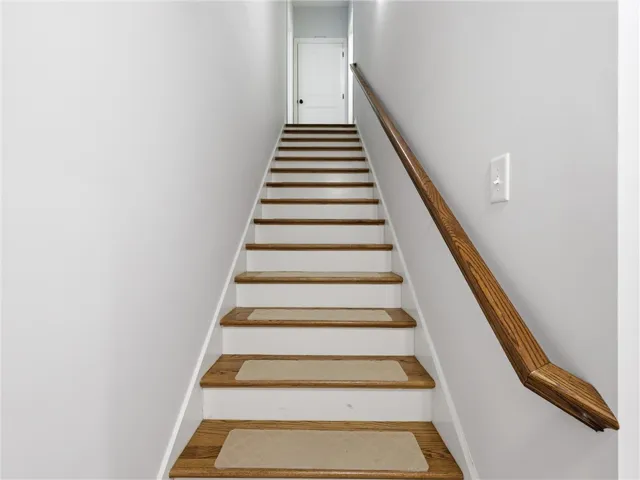 Ascend to comfort with a classic wooden staircase leading to a private upper level.