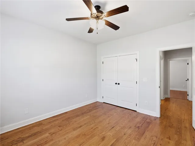 This inviting bedroom features rich hardwood flooring and convenient closet access.