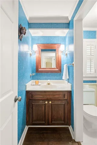This bathroom features a classic vanity with elegant sconces, creating a refined atmosphere.