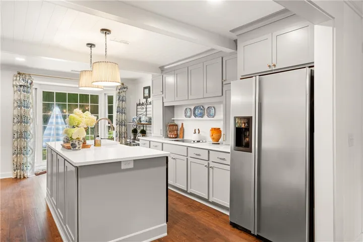 This bright kitchen features ample counter space, a large island, and modern stainless steel appliances.