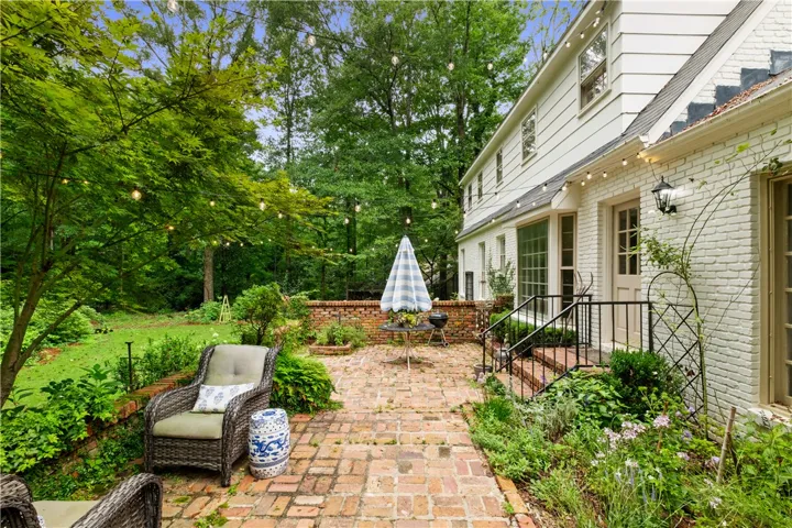 This private outdoor retreat features a brick patio and lush landscaping, perfect for relaxation and entertainment.
